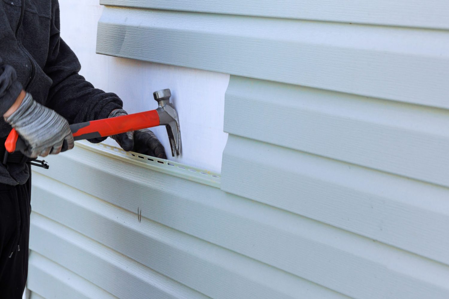 Reconstruction of exterior of house includes replacement of damaged plastic siding